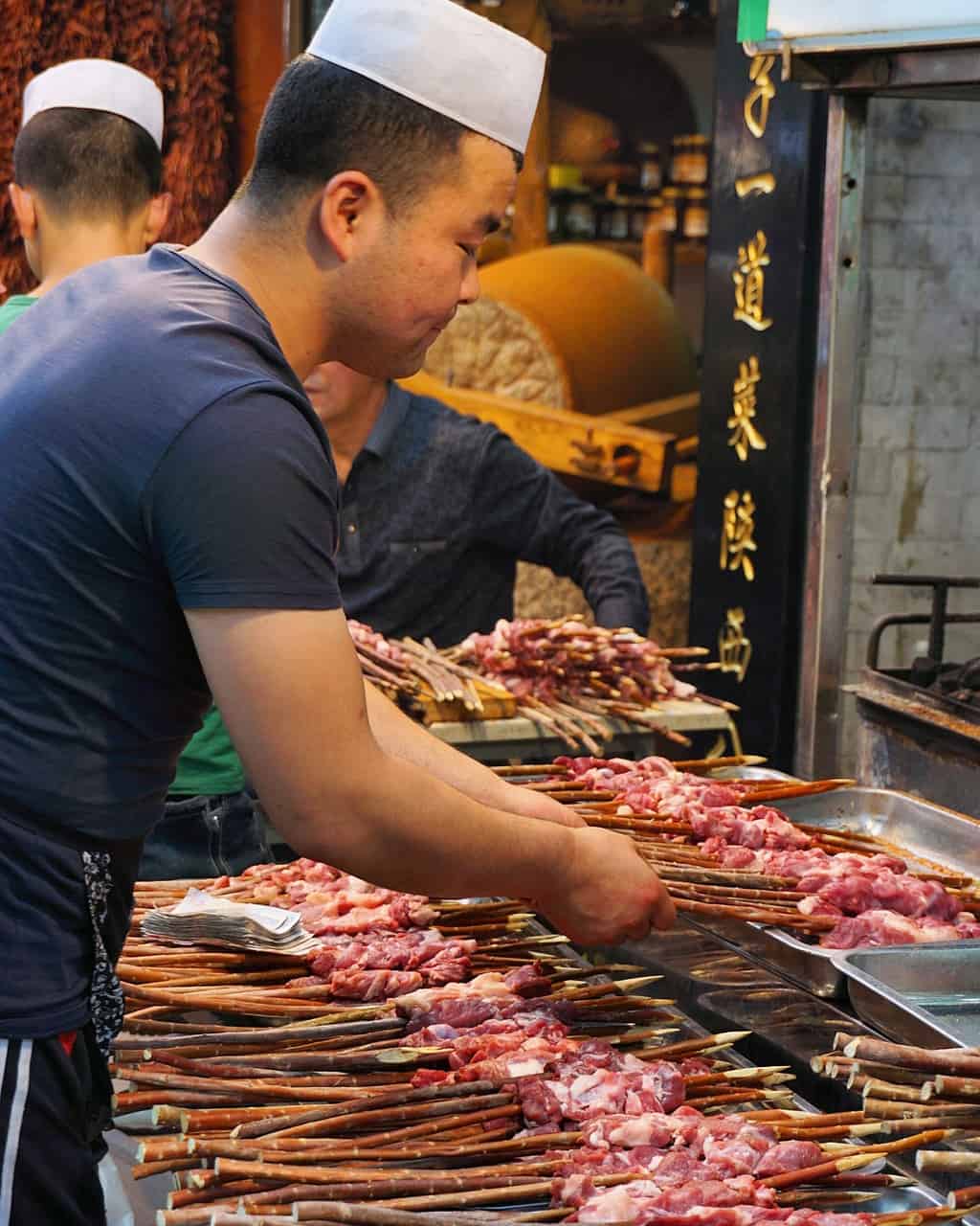 image of a man cooking meat skewers in Xi'an's Muslim quarter in China
