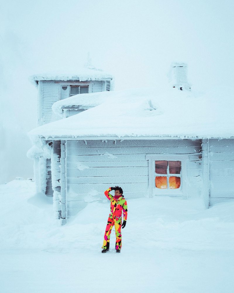 a woman in colourful winter gear walking in a snowy forest Finnish Lapland, Lapland destinations, Lapland Finland, Inghams