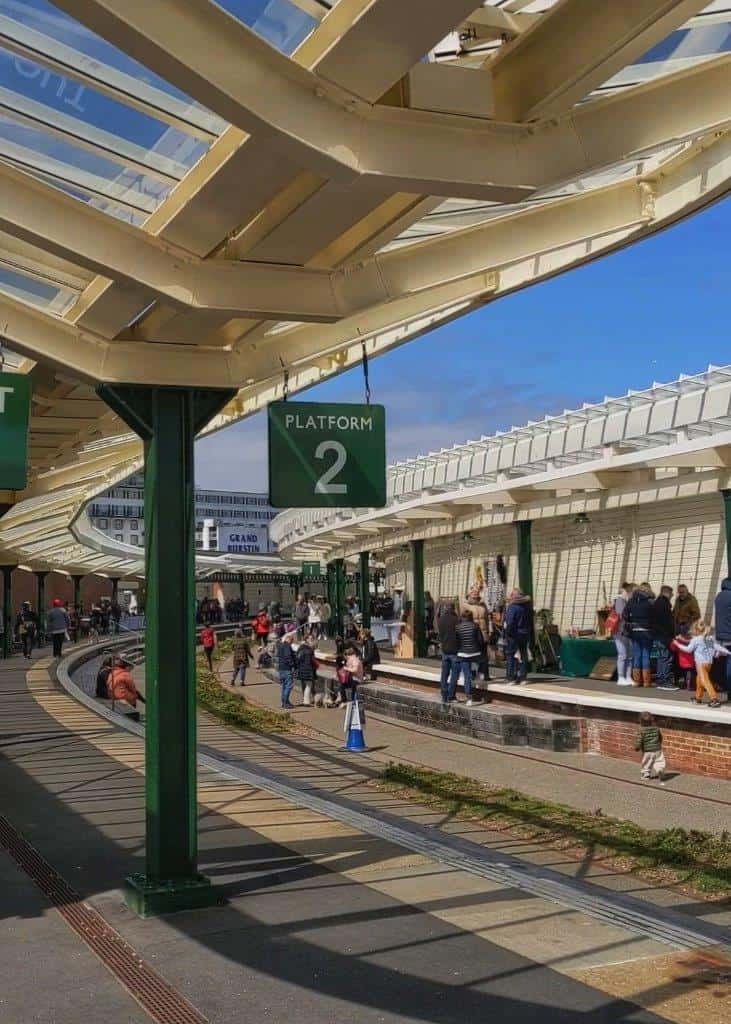 A restored ex-railway station showing the old rail tracks and platforms, now the location of a vibrant Sunday market